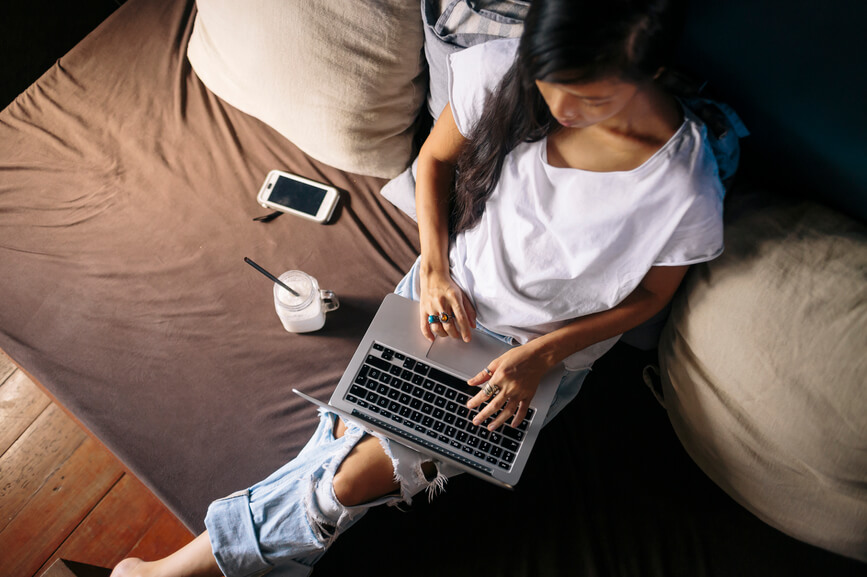 Homeschool mom creating homeschool high school transcript on bed